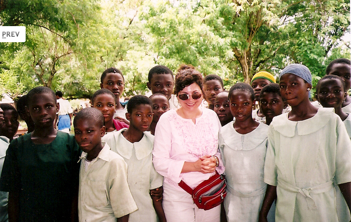 A woman standing in front of a group of children.